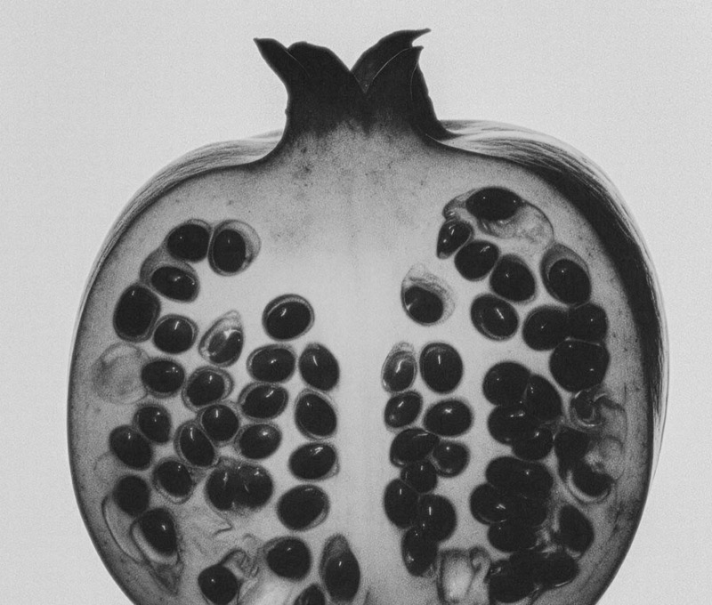 Black and white close-up of a halved pomegranate
